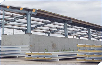 Why is it more cost-effective to use coated aluminum coils as sandwich panel materials?